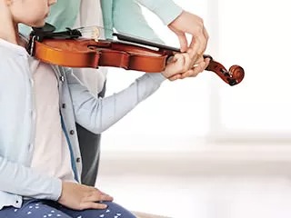 ヴァイオリンを真剣に弾く女性の写真